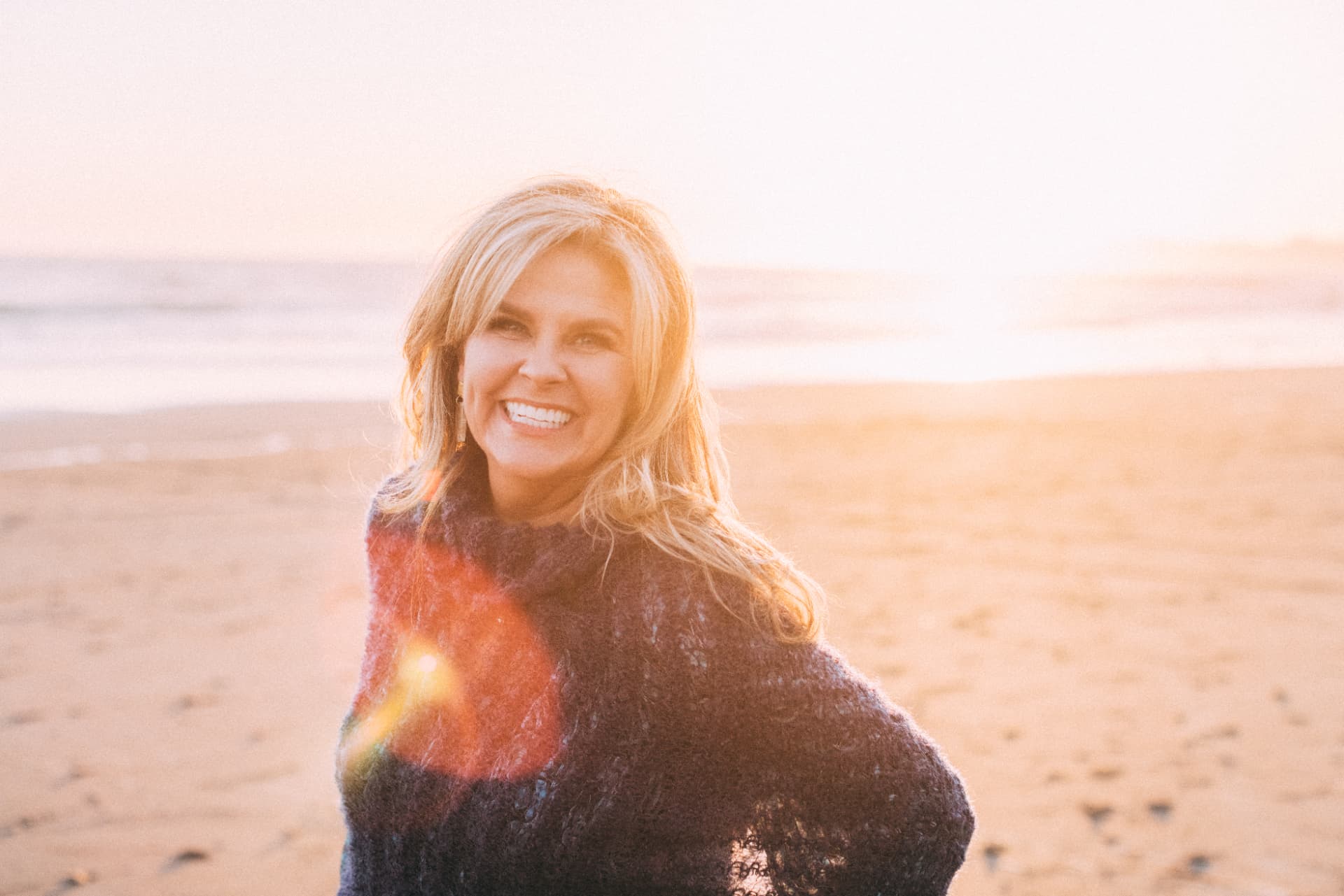 Anne Robie smiling on the beach at sunset